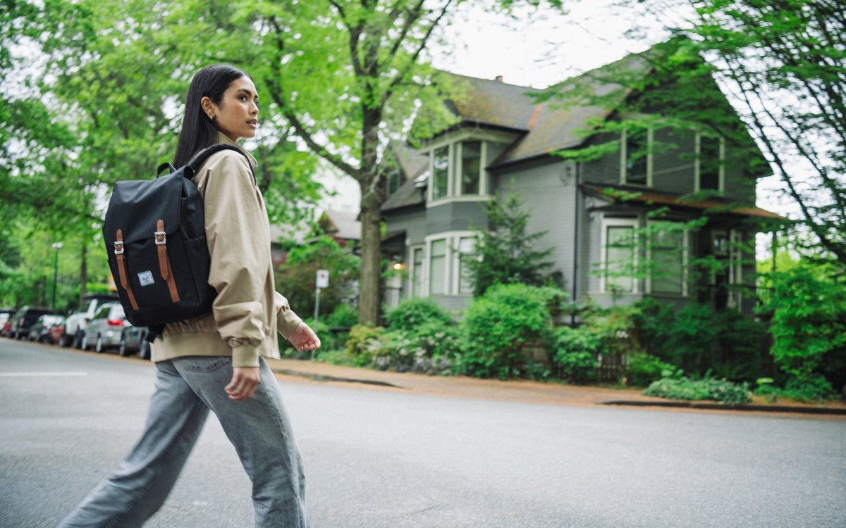Herschel Supply Co. Retreat Small Backpack in black, featuring a classic design with dual magnetic strap closures and a front storage sleeve.
