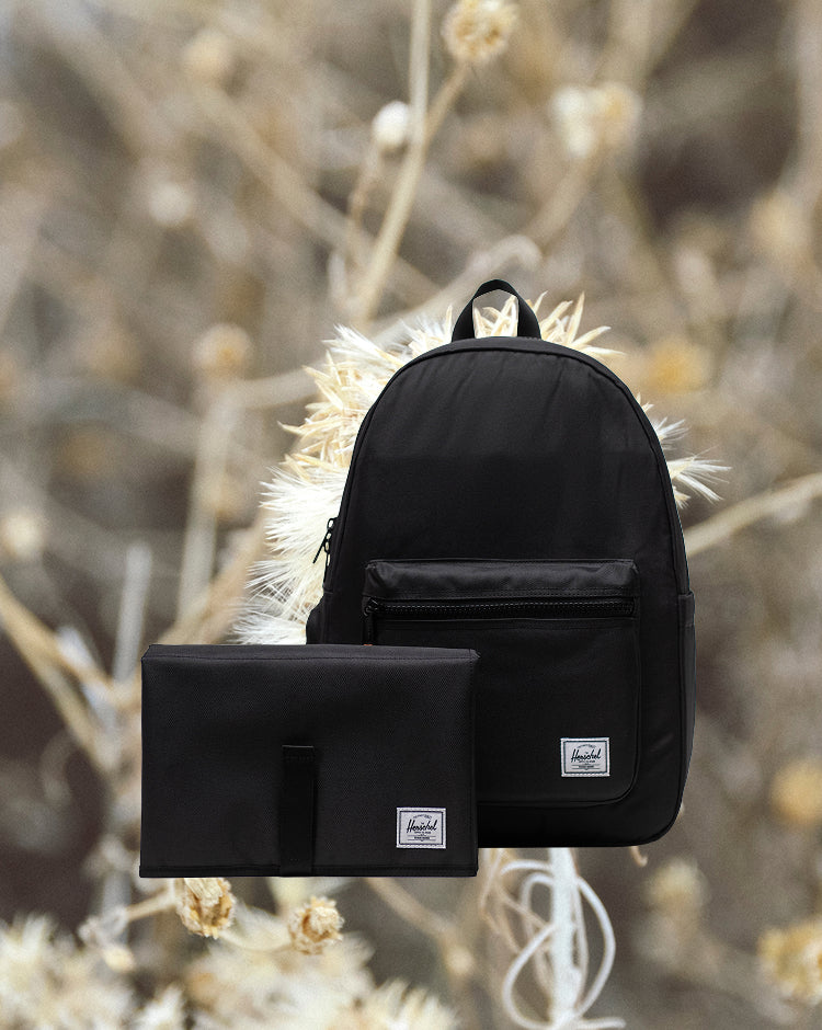 Herschel Supply Co. Settlement Backpack Diaper Bag in black, featuring a classic design with a front storage pocket and exposed zippers.