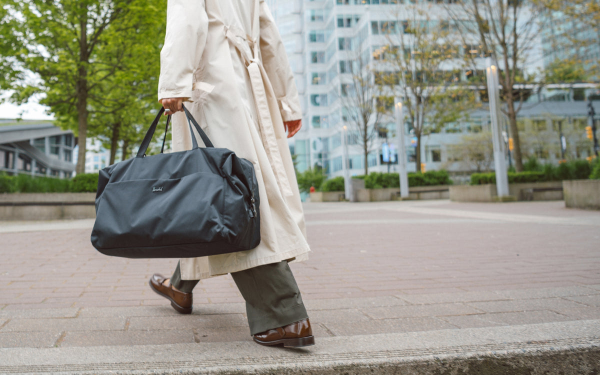 Herschel Supply Co. Maia Weekender bag in solid black, featuring dual top carry handles and a clean, minimalist design for travel or daily use.