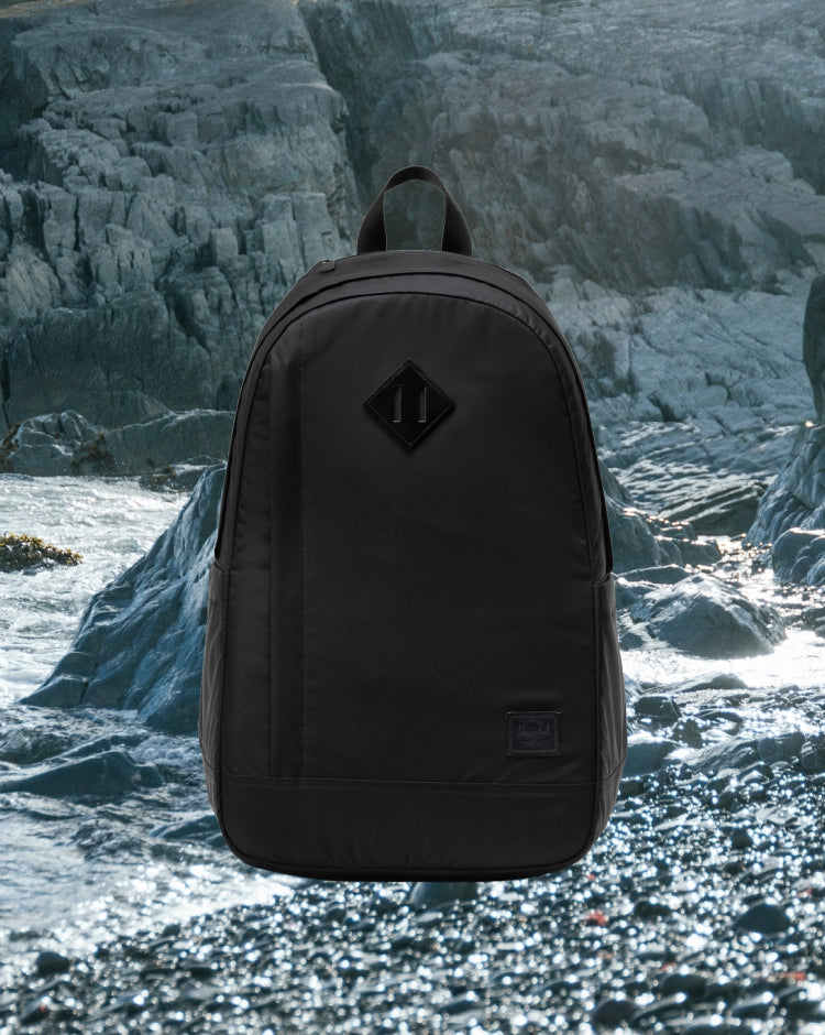 Herschel Seymour Backpack in black, showing the front view with classic design, shoulder straps, and zippered compartments.