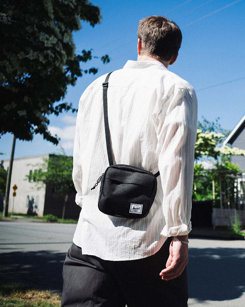 Herschel Classic Crossbody bag in solid black, showcasing its compact, functional design for everyday essentials.