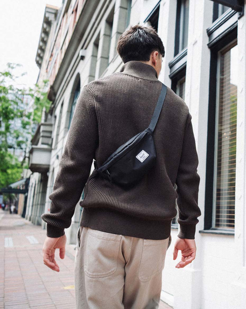 Herschel Supply Co. Classic Hip Pack in black, shown from the front featuring a zippered main compartment and adjustable strap.