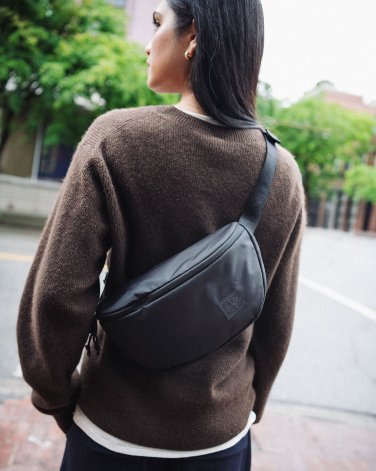 Herschel Supply Co. Kaine Hip Pack in black, featuring a front view of the classic waist bag with adjustable strap.