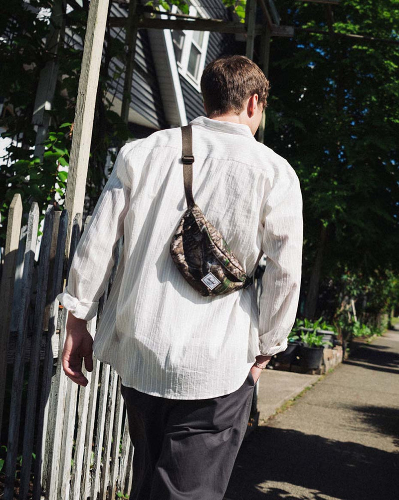 Herschel Supply Co. Classic Hip Pack in Realtree APX Camo pattern, showing the outdoor-inspired waist bag.