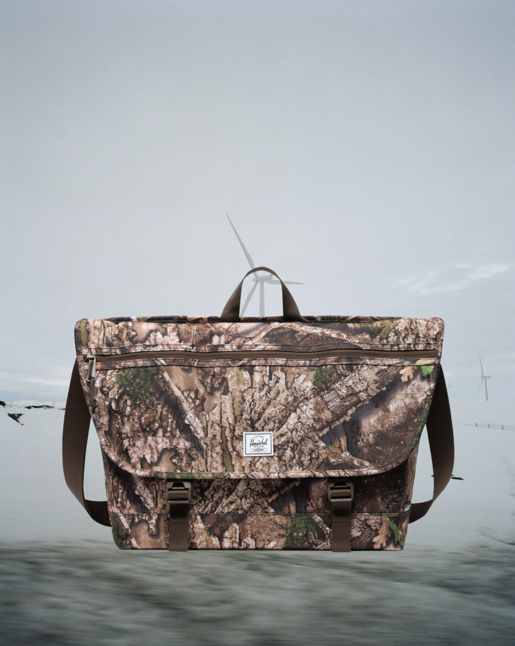 Herschel Supply Co. Realtree Cove Messenger bag in Realtree APX Camo pattern on a mobile screen view.
