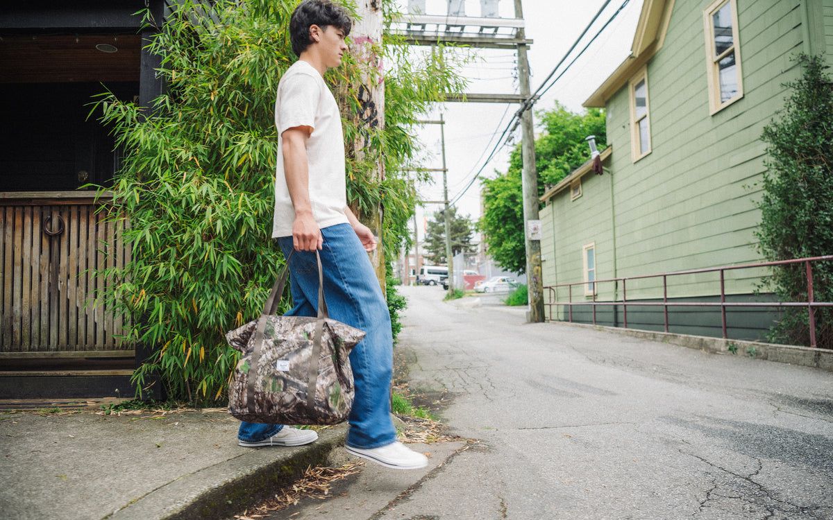 Herschel Supply Co. Realtree Portland Packable Tote in the Realtree APX Camo camouflage pattern.