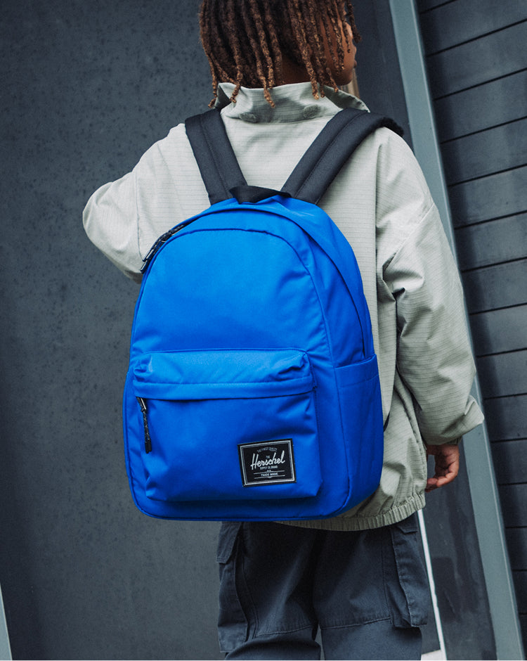 Herschel Classic Backpack Twill in Dazzling Blue. Front view showing the main compartment and front pocket on a mobile layout.