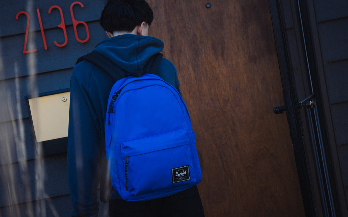 Herschel Classic XL Backpack Twill in Dazzling Blue, shown from the front on a lifestyle desktop background.