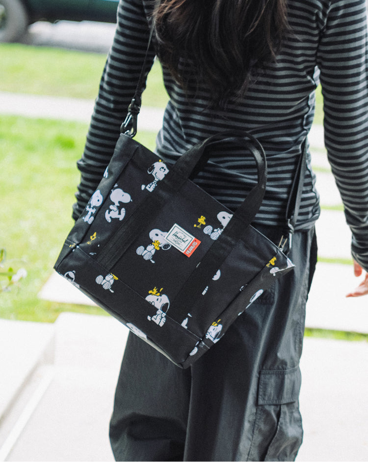 Herschel Supply Co. Peanuts Herschel Heritage Small Tote in Snoopy and Woodstock Black lifestyle view.