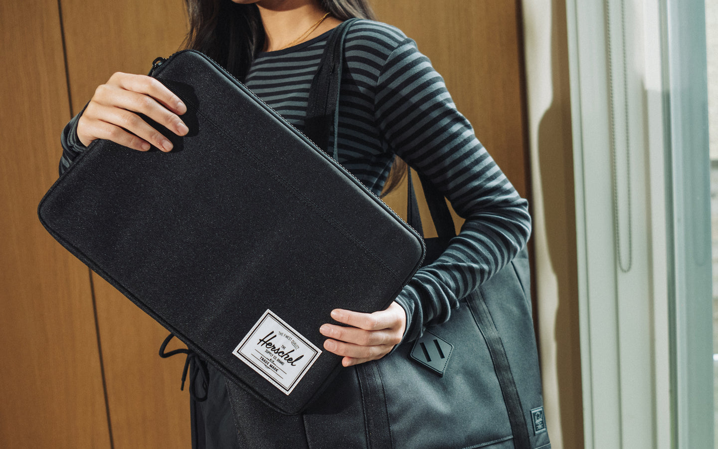 Herschel Supply Co. Anchor 14 Inch Sleeve in black displayed on a desktop background, highlighting its clean, minimalist tech protection design.