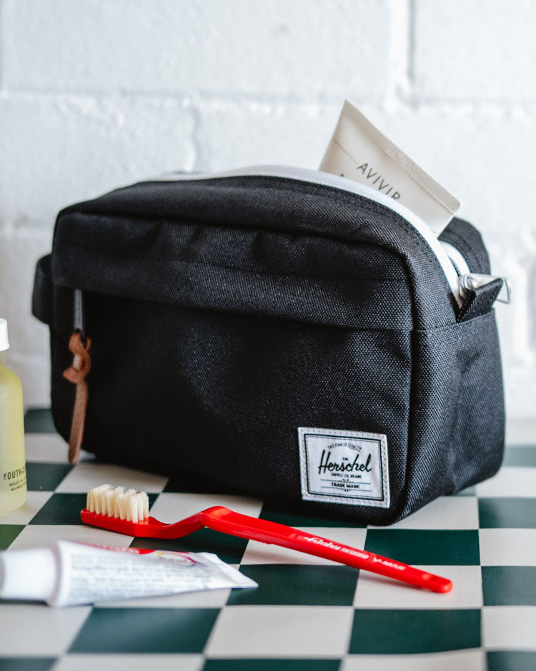 Herschel Supply Co. black Chapter Small Travel Kit featuring a convenient side carrying handle and zippered front storage pocket.