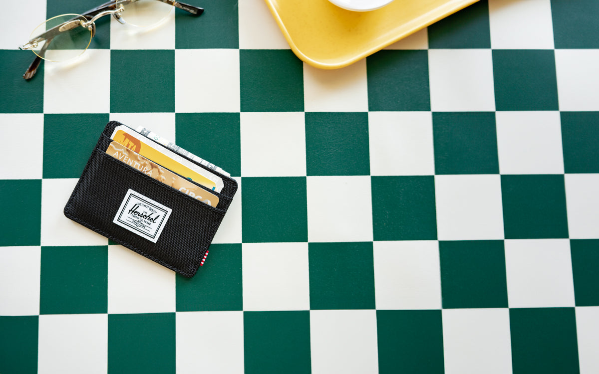 Herschel Supply Co. Charlie Cardholder in classic black, showcasing its slim design, multiple card slots, and signature striped liner.