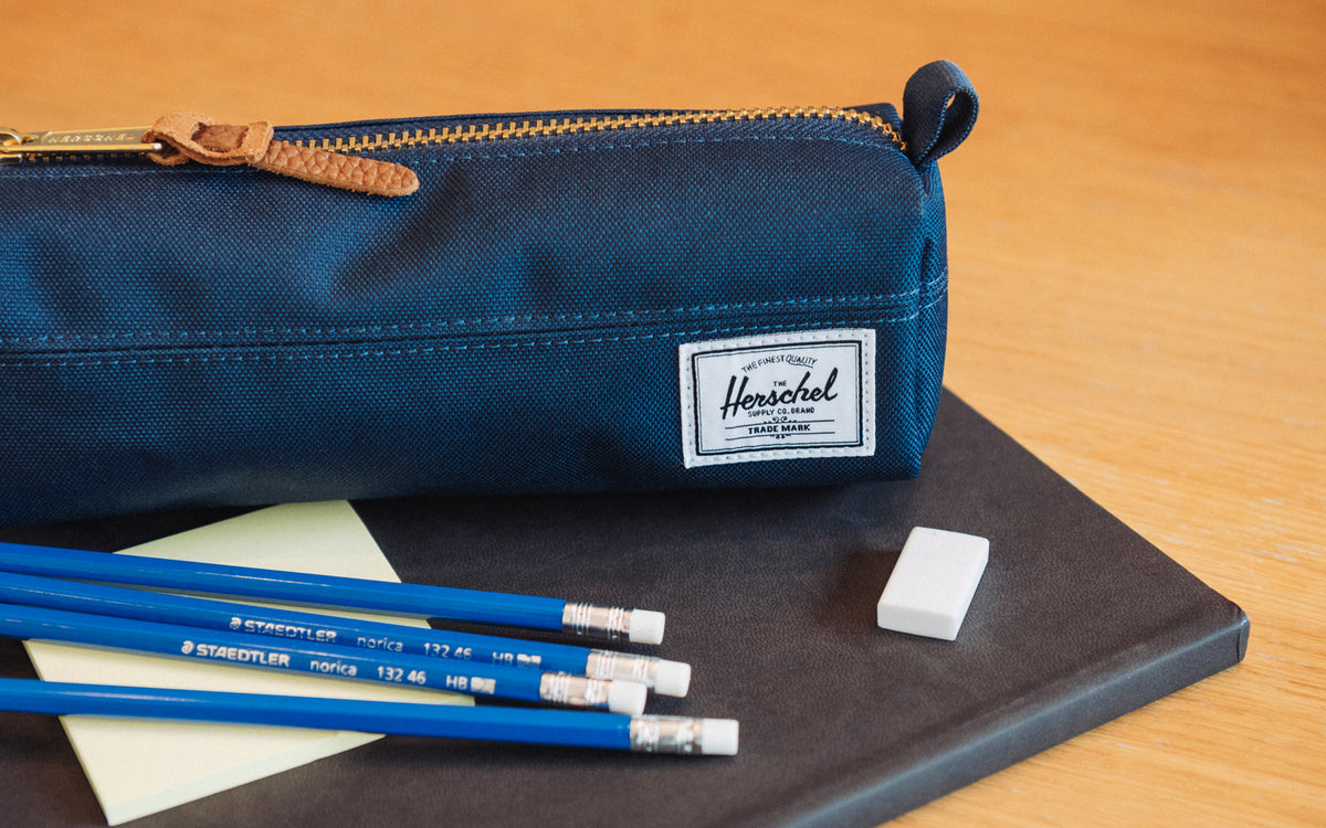 Herschel Supply Co. Settlement Pencil Case in navy blue, featuring a classic zippered design with a convenient side carrying handle.