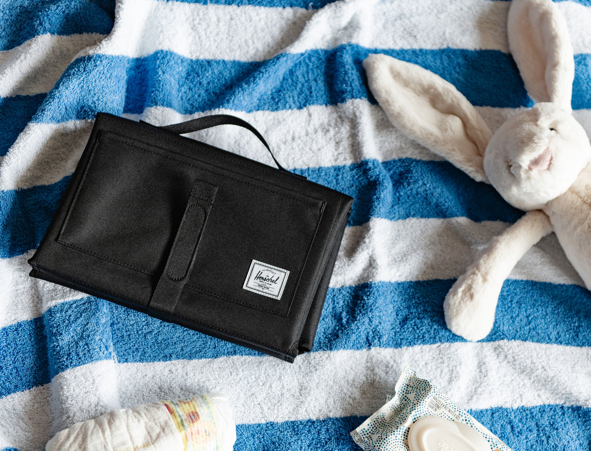 Herschel Supply Co. Sprout Change Mat in classic black, unfolded to show the clean padded surface and compact portable design for easy travel.