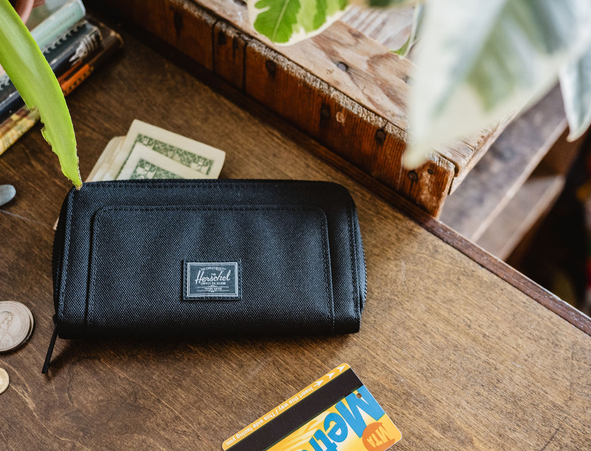 Herschel Supply Co. Thomas Wallet in Black Tonal displayed open, showing internal card slots, coin pocket, and sleek design.