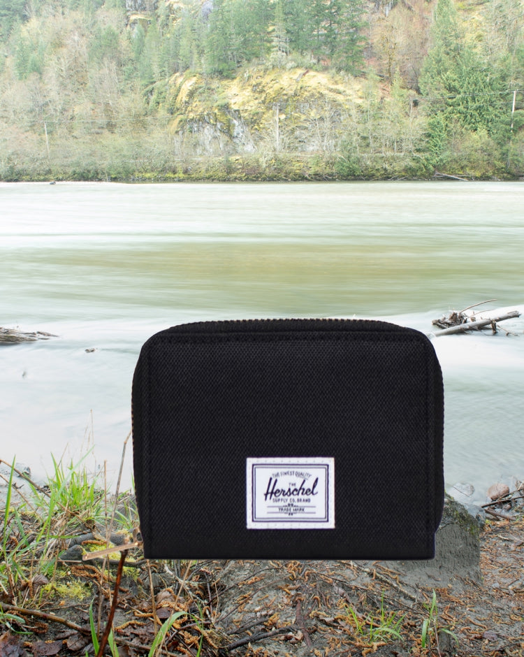 Herschel Supply Co. Tyler Wallet in black, featuring a full-zip bifold design with internal card slots and a center divider.