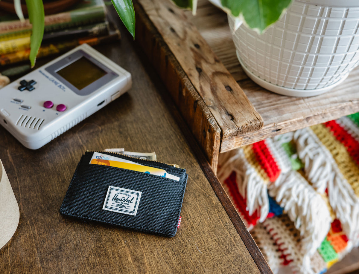 Herschel Supply Co. Oscar Cardholder wallet in solid black, showcasing its compact design and multiple card slots.