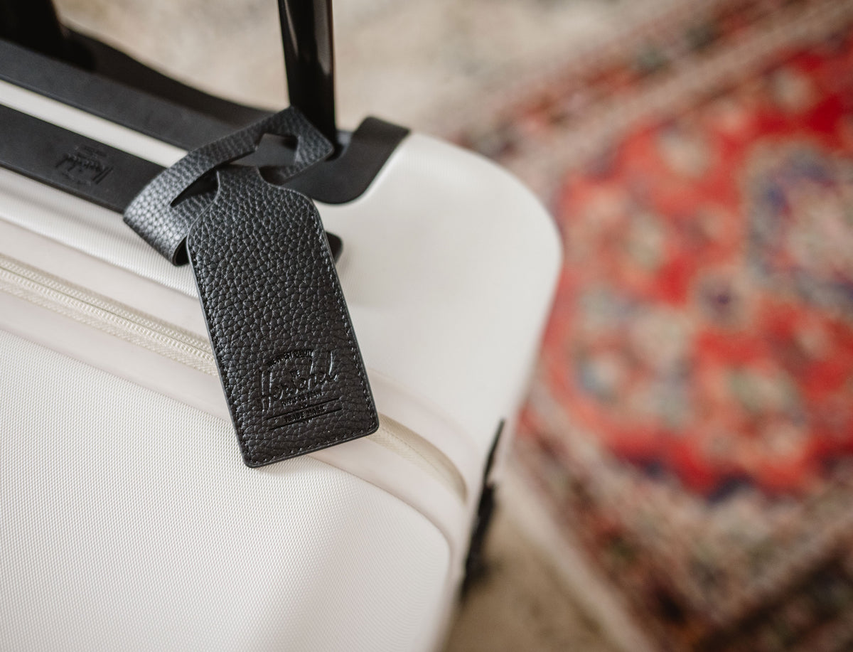 Herschel Supply Co. black vegan leather luggage tag shown from the front to highlight its sleek, durable design.