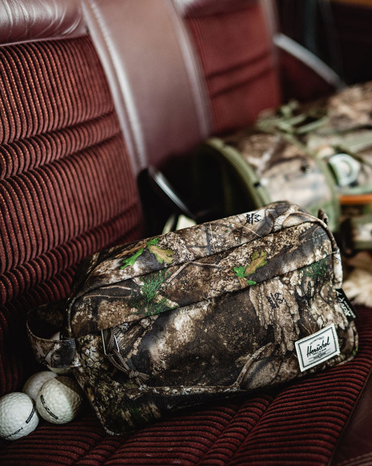 Herschel Supply Co. Realtree Chapter Travel Kit in Realtree APX Camo, featuring a zippered main compartment and front pocket.