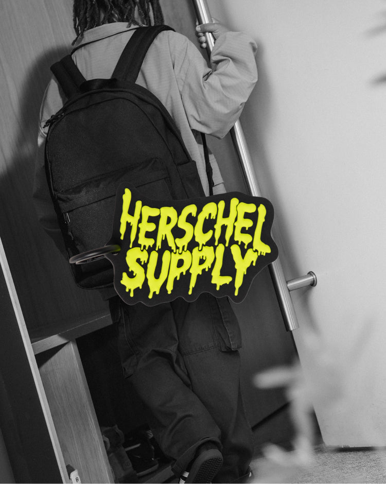 A black Herschel Supply Co. Slime bag charm accessory in the shape of a dripping slime droplet.