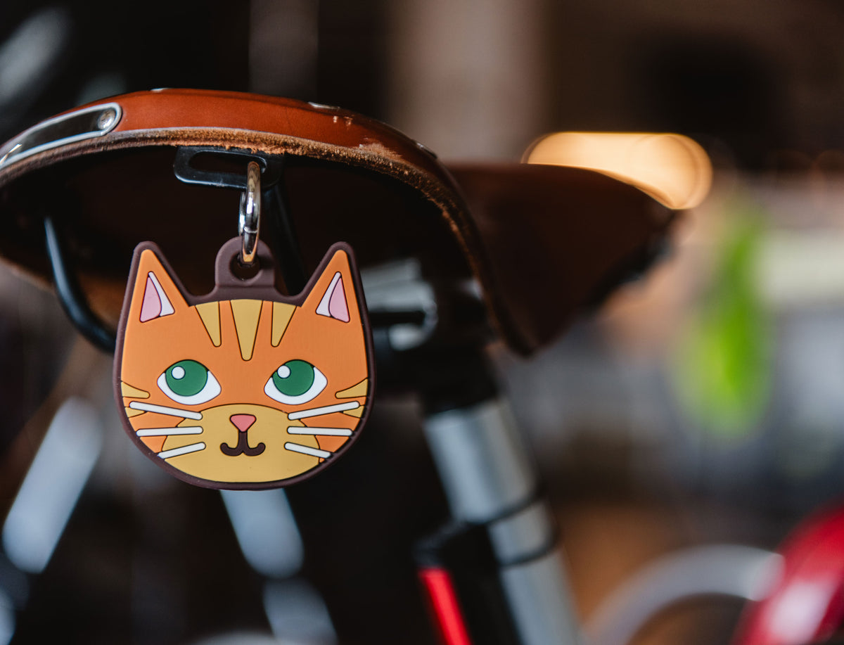 Herschel Supply Co. Orange Cat Bag Charm displayed as a whimsical accessory attached to a backpack.