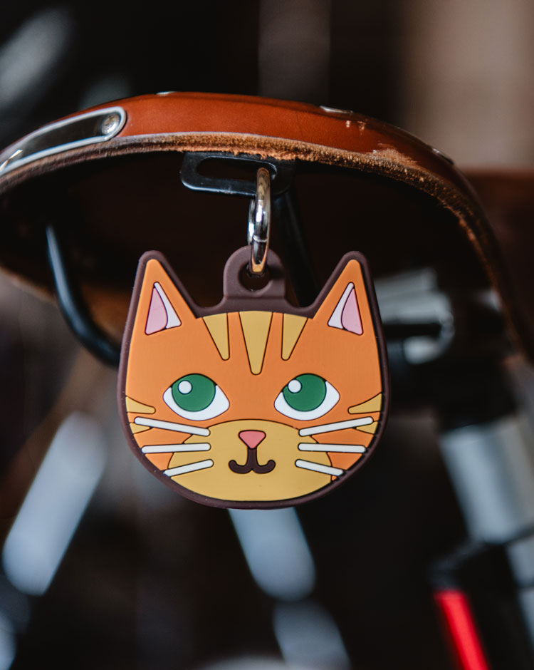 Orange Herschel Cat Bag Charm made of silicone with an attached metal keyring, designed as a playful accessory for bags and keys.