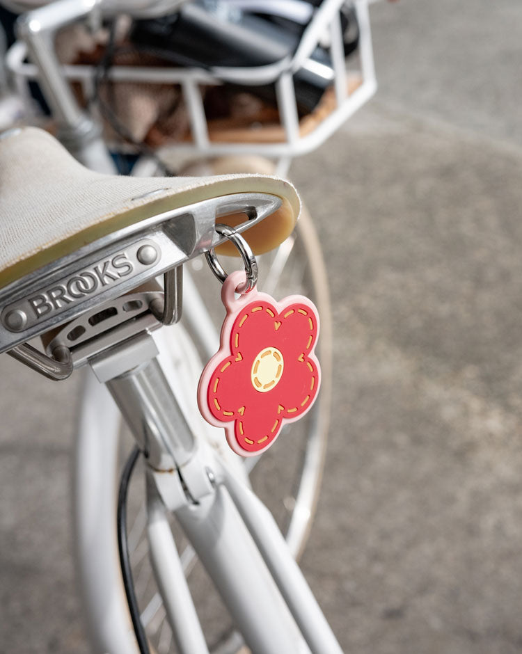 Herschel Supply Co. Pink Daisy Bag Charm shaped like a daisy flower with a gold-tone clip.