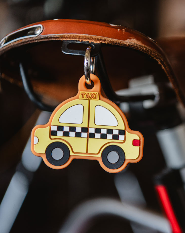 Herschel Supply Co. yellow taxi silicone bag charm with a metal keyring.